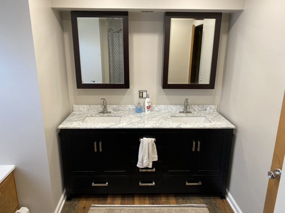 a bathroom with two sinks and two mirrors .