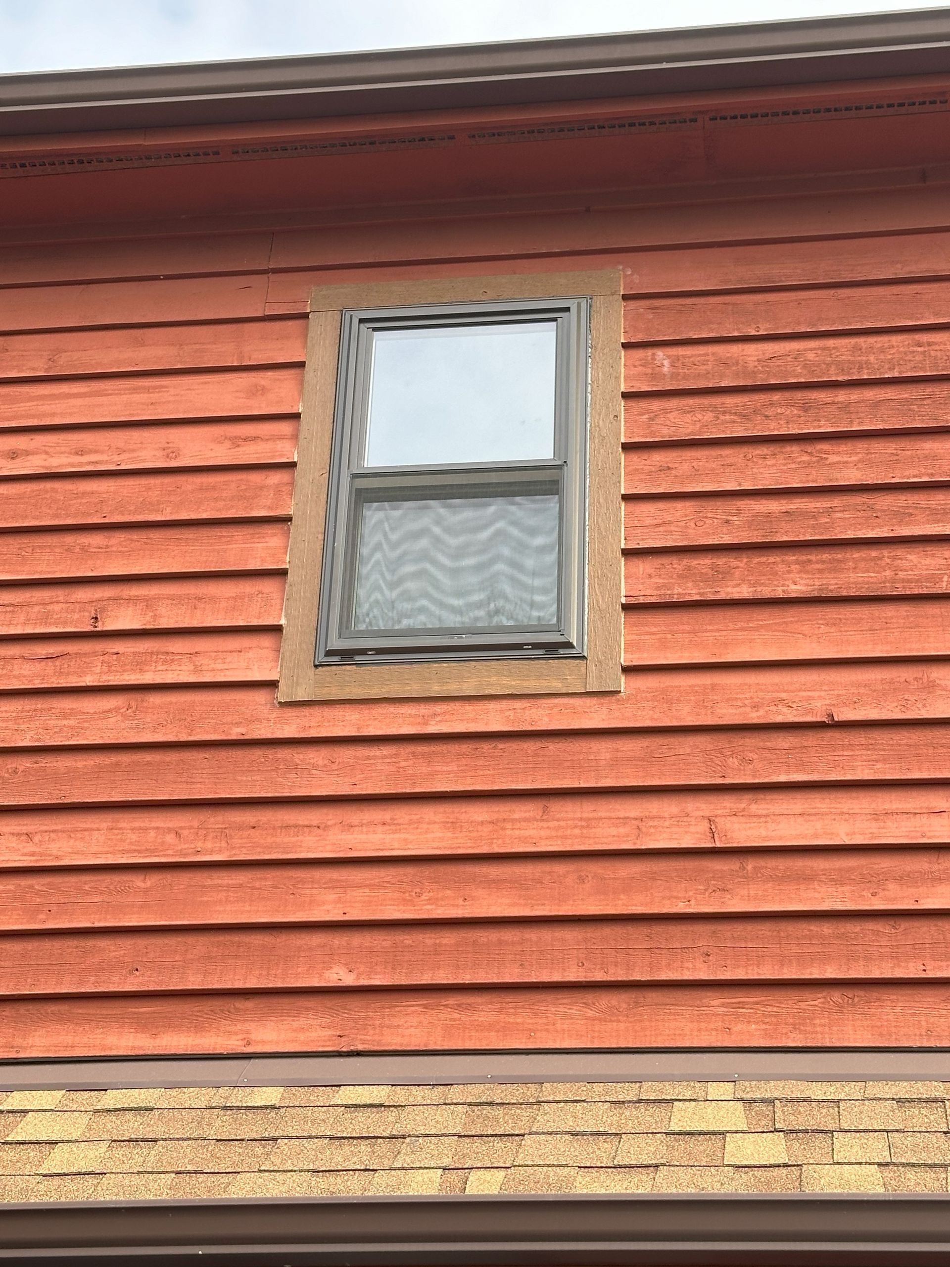 a red house with a window on the side of it .