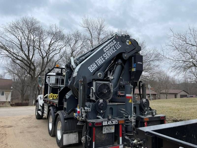 A large crane is attached to the back of a truck.