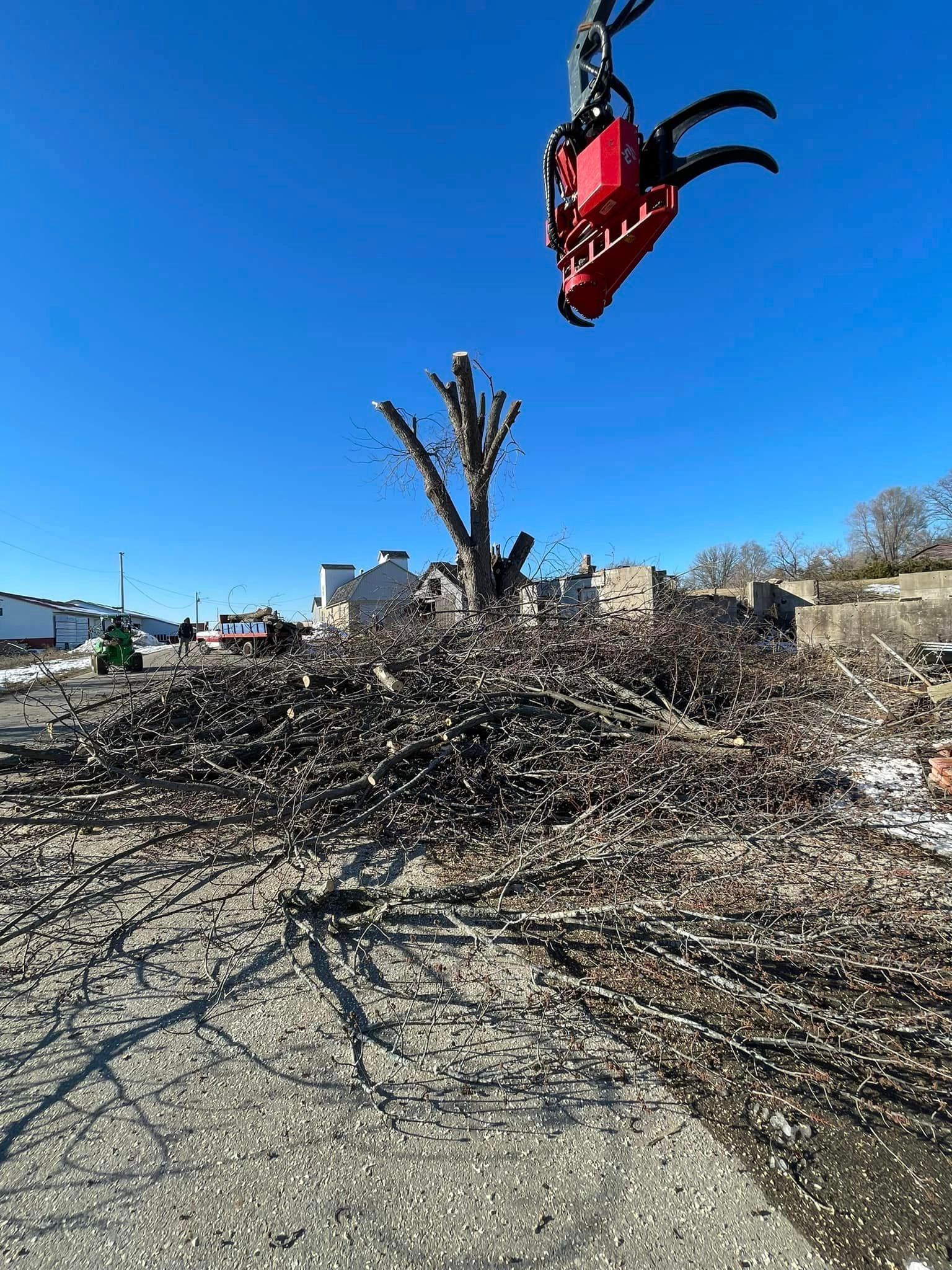 A large pile of wood is being lifted by a crane.