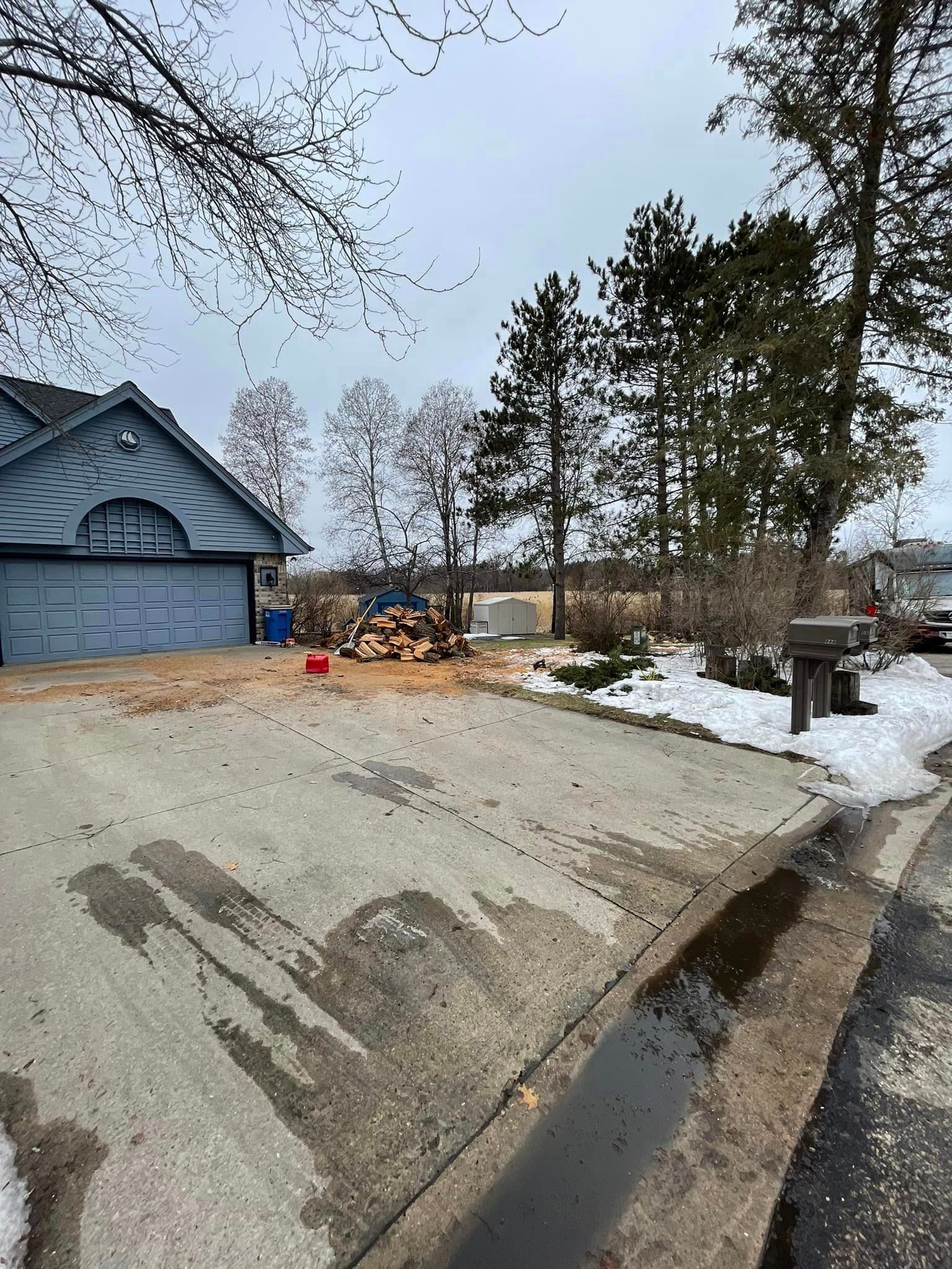 A house with a garage and a mailbox on the side of the road.