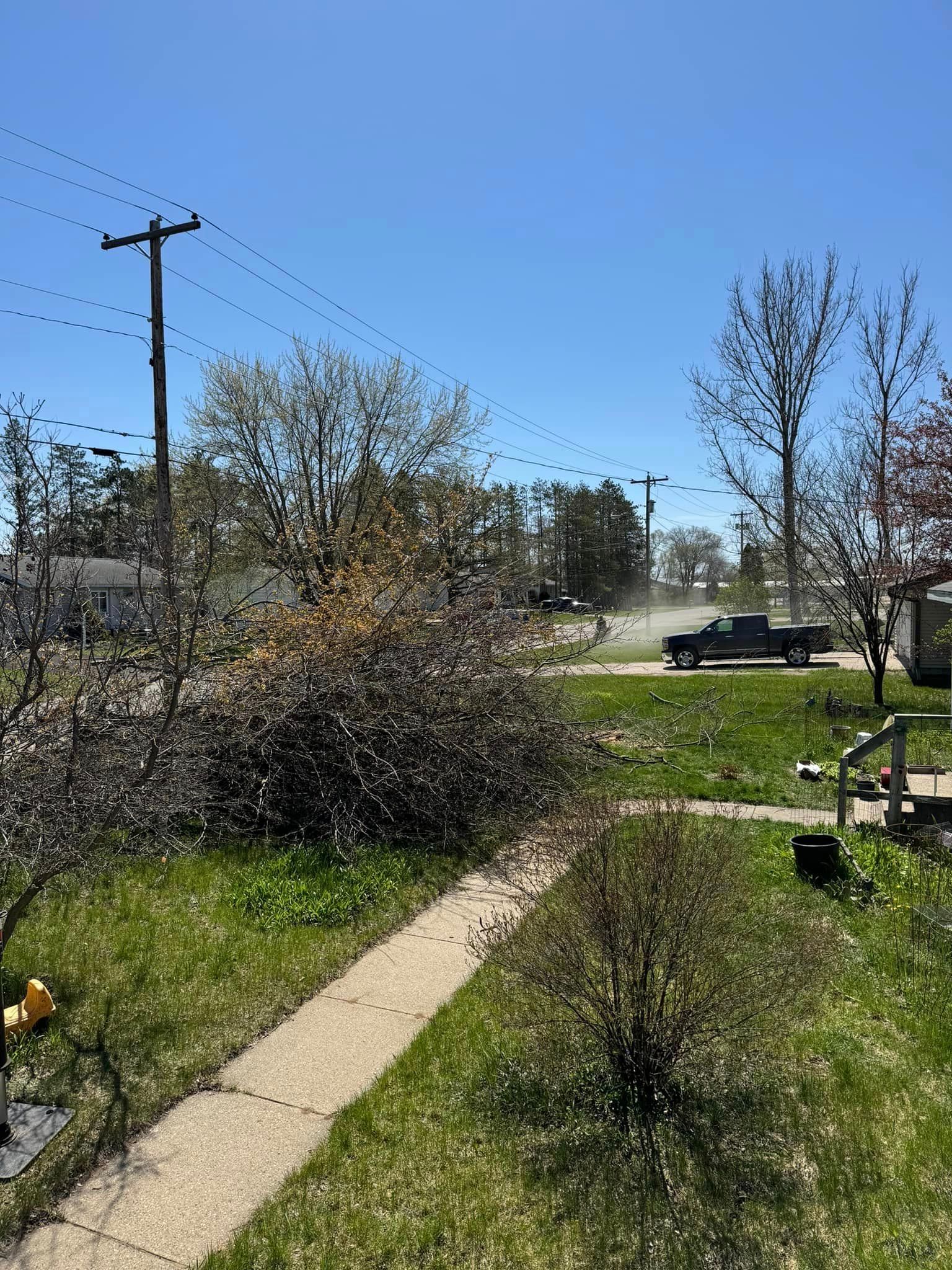 A truck is driving down a street next to a sidewalk.