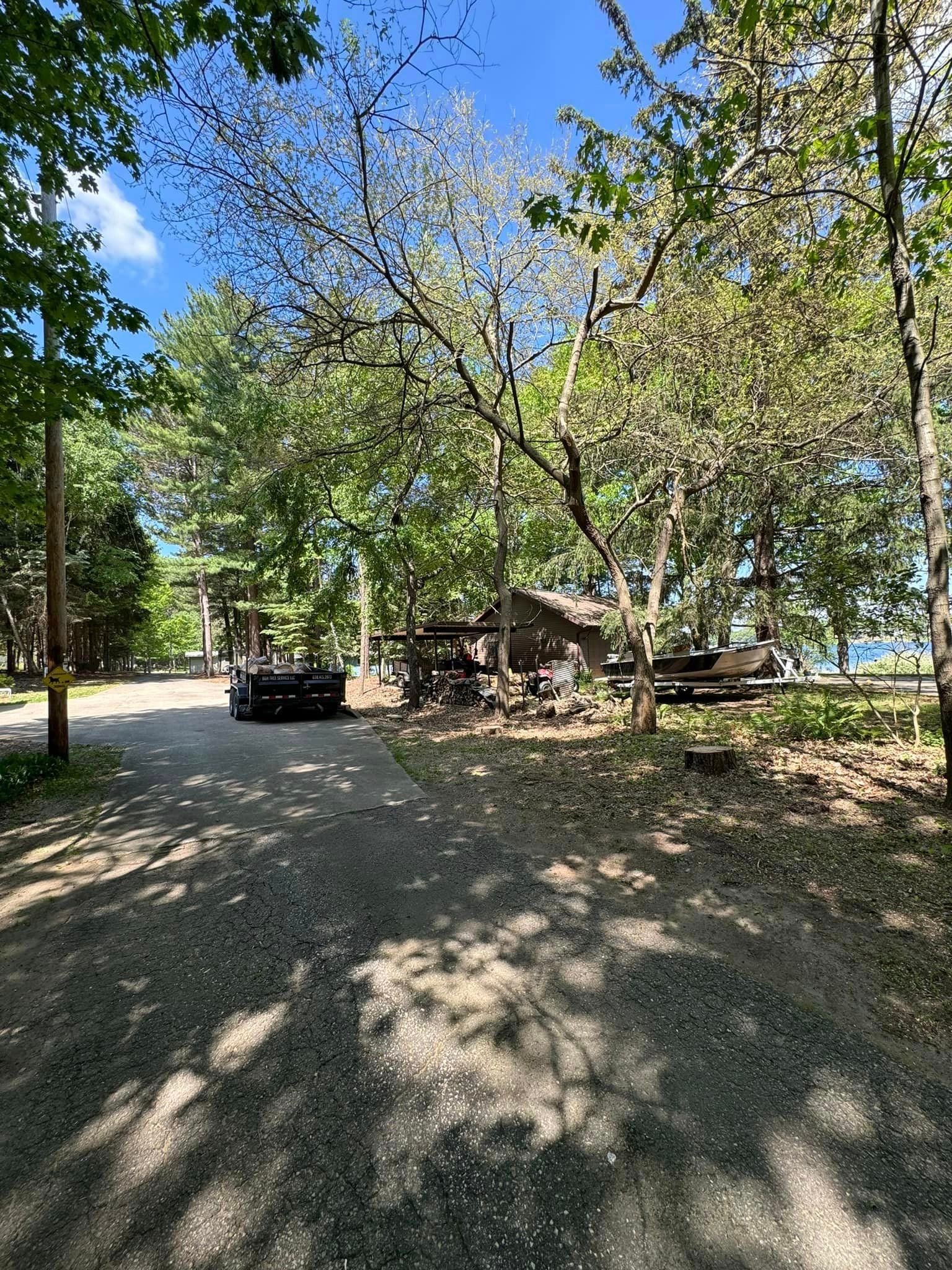 A car is parked in a parking lot surrounded by trees.