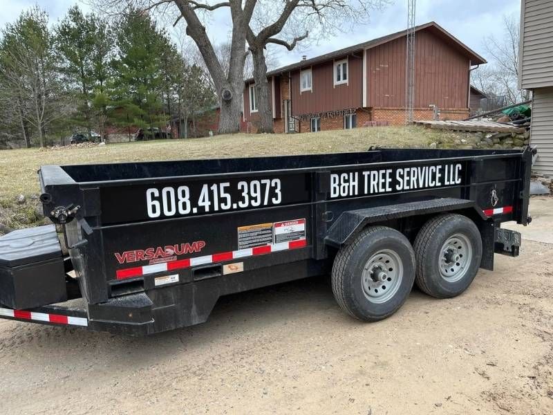 A dumpster trailer is parked in front of a house.