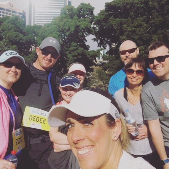 A group of people are posing for a picture and one of them has a yellow tag that says oeoe2