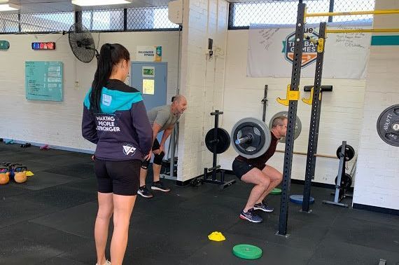 A group of people are doing yoga in a gym.