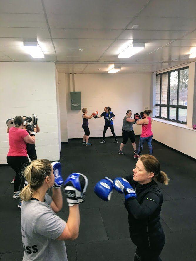 A group of women are boxing in a gym.