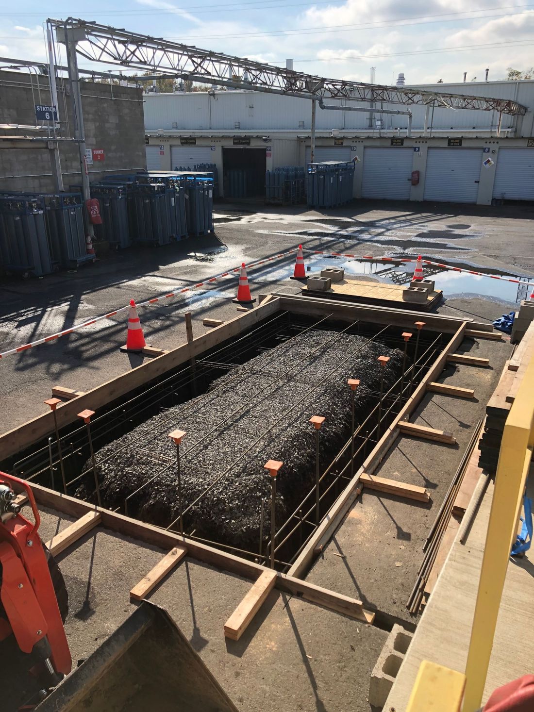 A large hole in the ground is being filled with concrete.