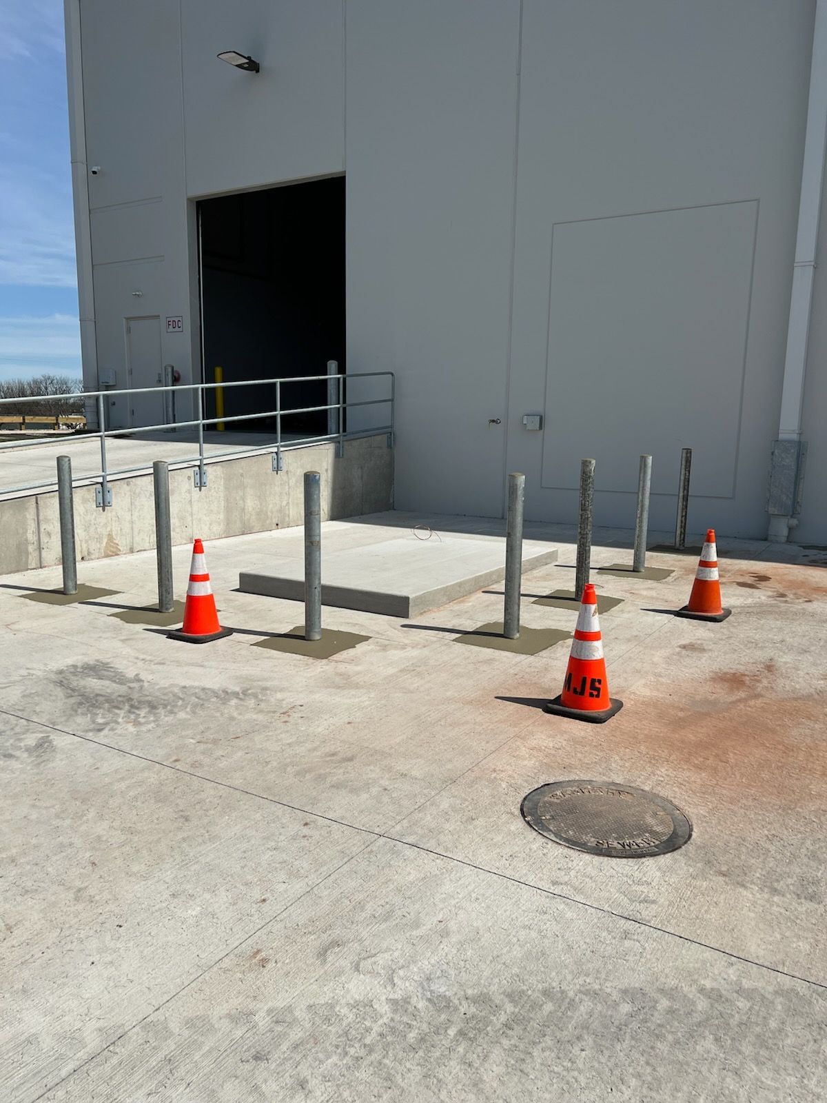 A row of orange and white traffic cones are sitting in front of a building.