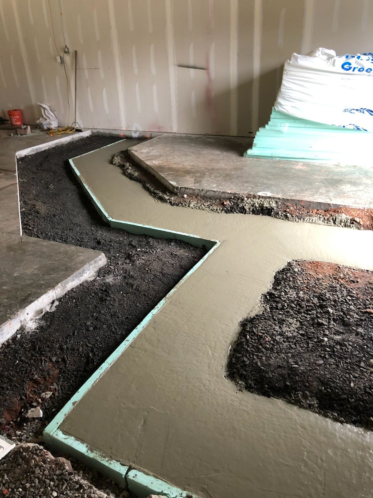 A concrete walkway is being built in a room.