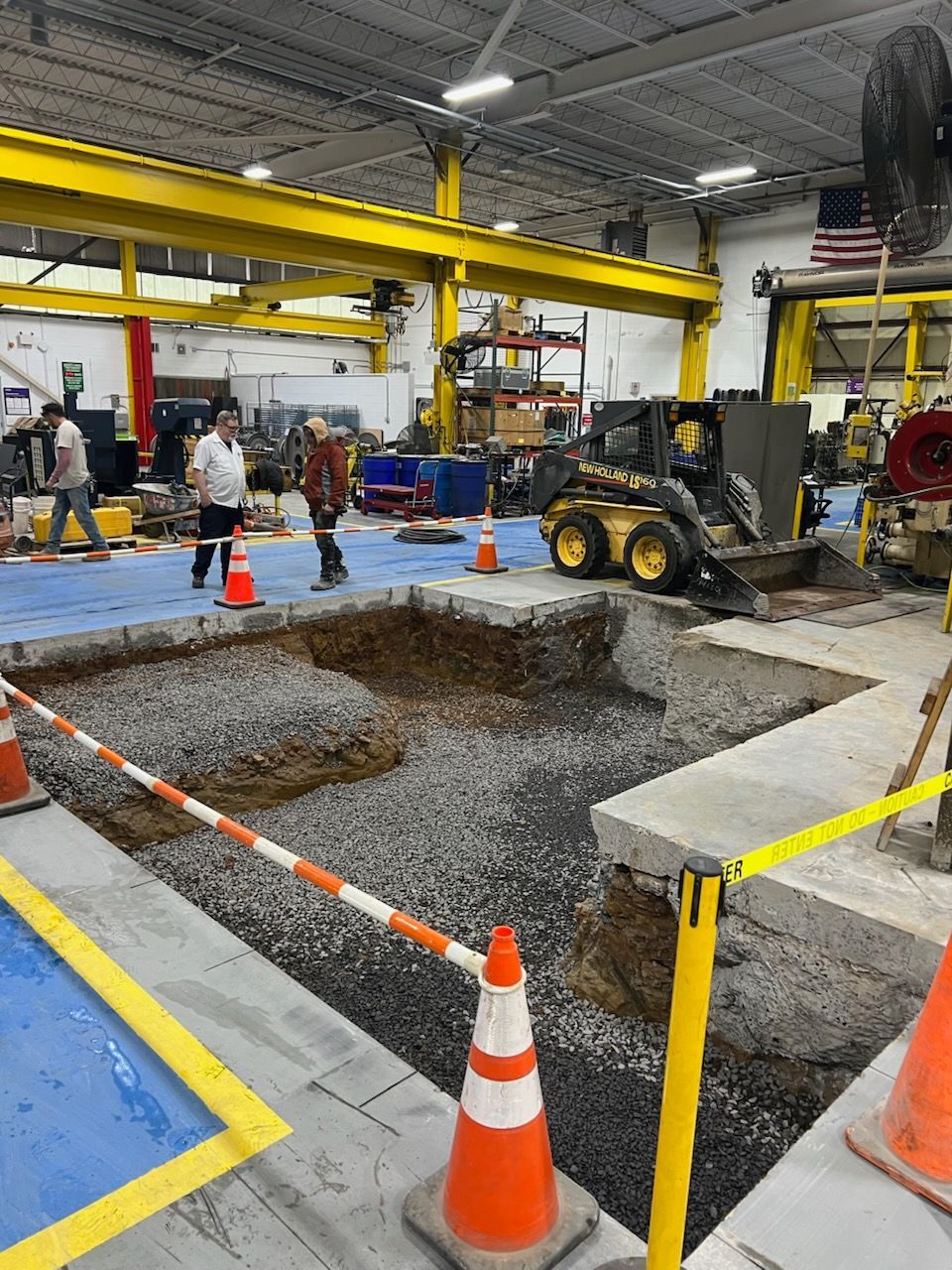 a man is pouring concrete into a hole with a shovel