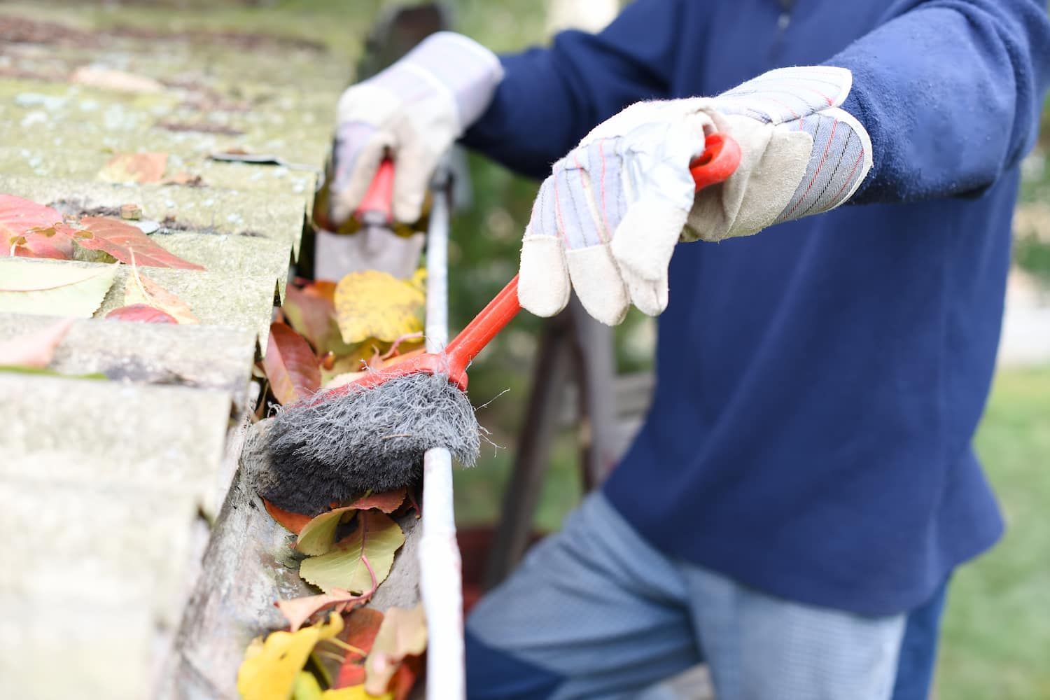 A Person Is Cleaning A Gutter With A Brush — GPS Plumbing, Drainage & Gasfitting In Dubbo, NSW