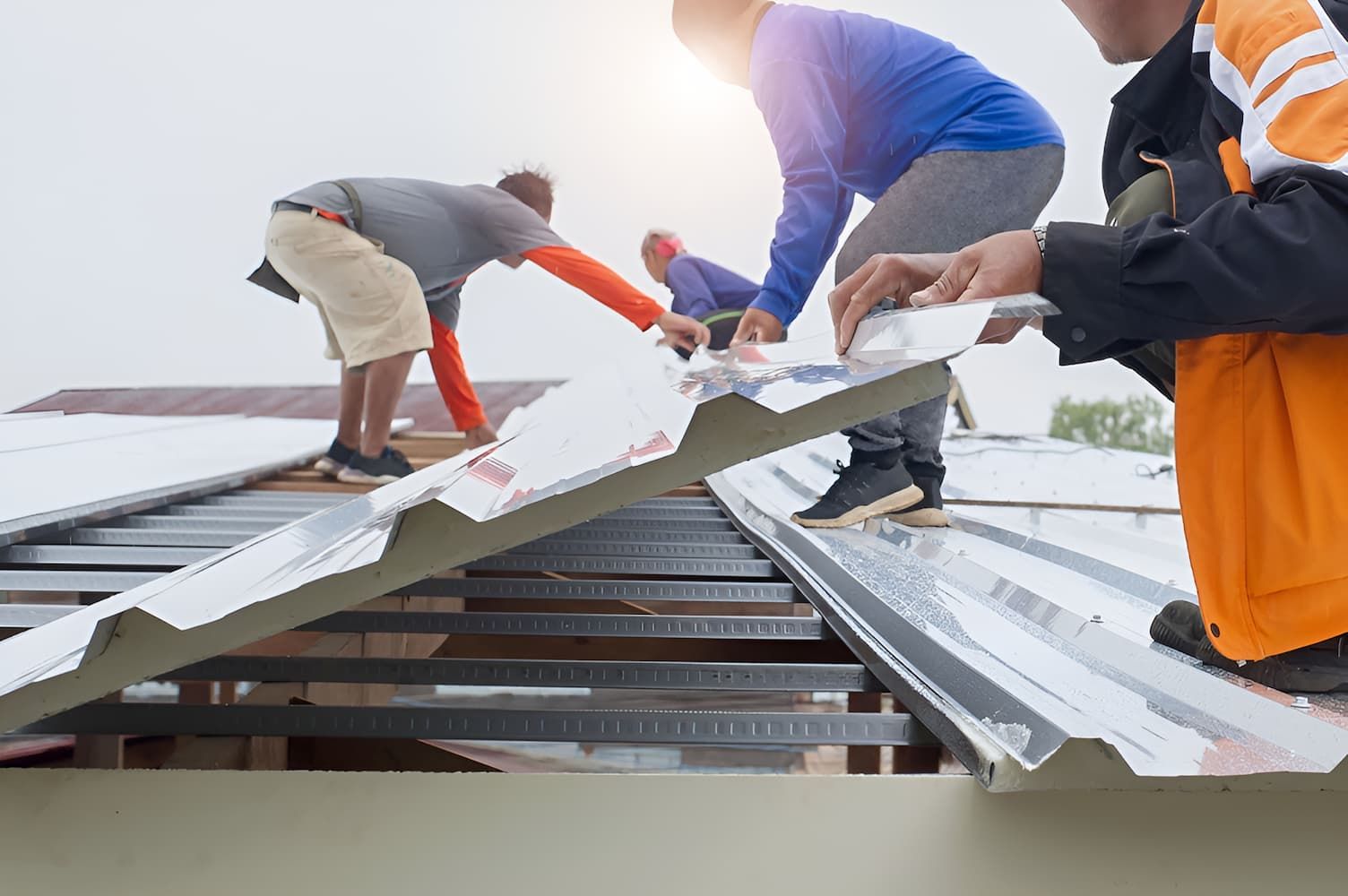A Group Of Men Are Working On A Metal Roof — GPS Plumbing, Drainage & Gasfitting In Dubbo, NSW