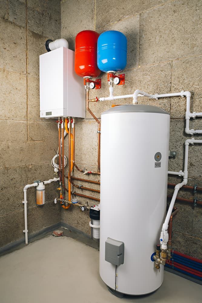 A Water Heater Is Sitting In A Room Next To A Boiler — GPS Plumbing, Drainage & Gasfitting In Dubbo, NSW