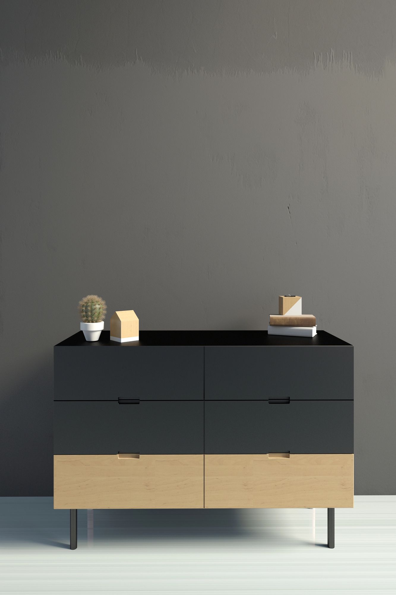 Moderna cassettiera nera e in legno con piccoli decori, appoggiata a una parete grigia.