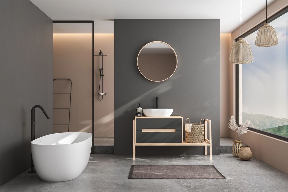 Bagno moderno con parete grigio scuro, vasca bianca, mobile lavabo in legno e ampia finestra.
