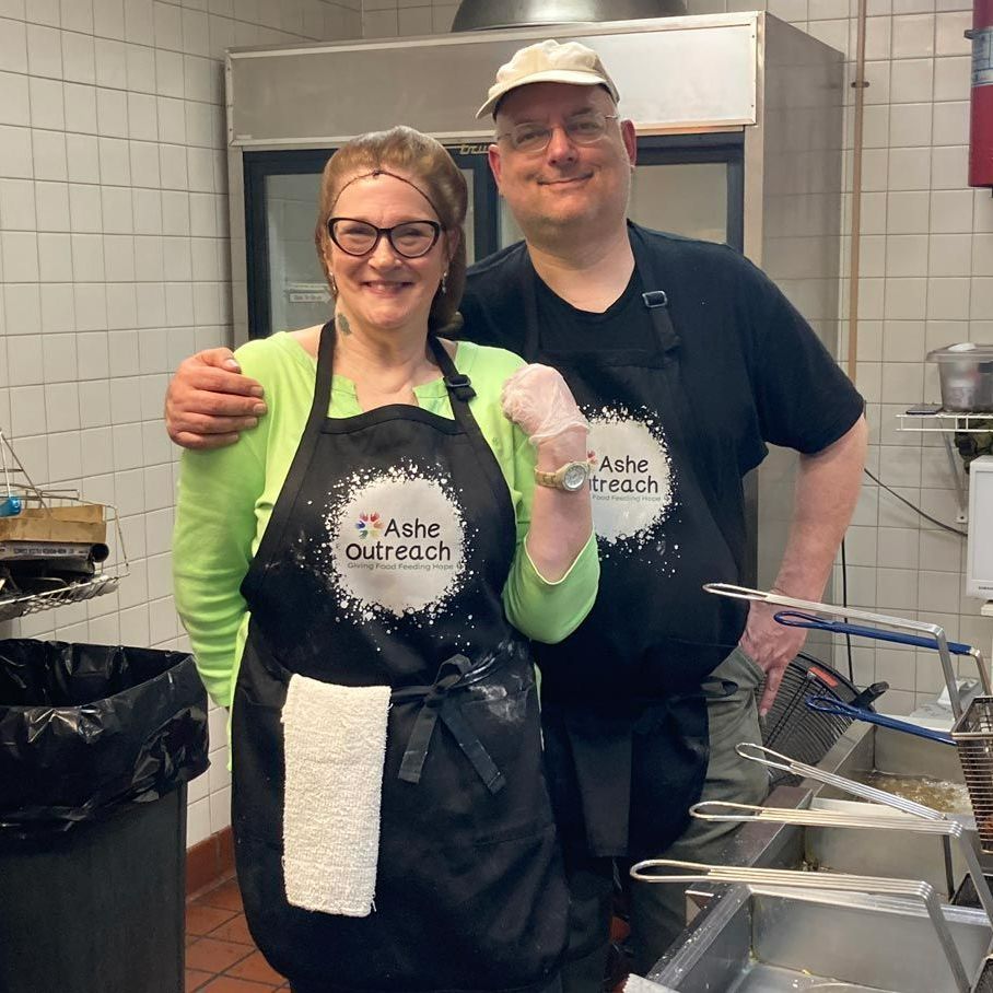 A man and a woman wearing aprons that say ashes outreach