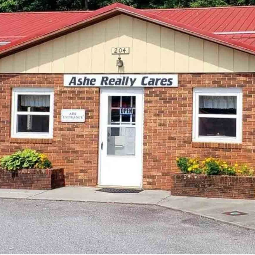 A brick building with a sign that says ashe really cares