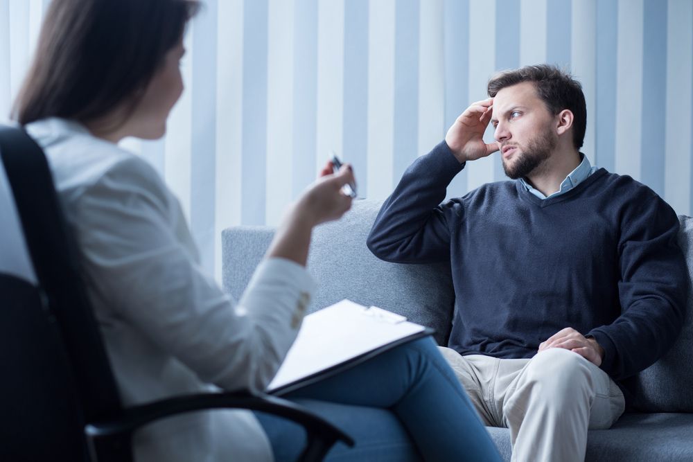 Depressed Young Man Talking With Female Psychiatrist — Gold Coast Detox and Rehab Services in Rockhampton, QLD