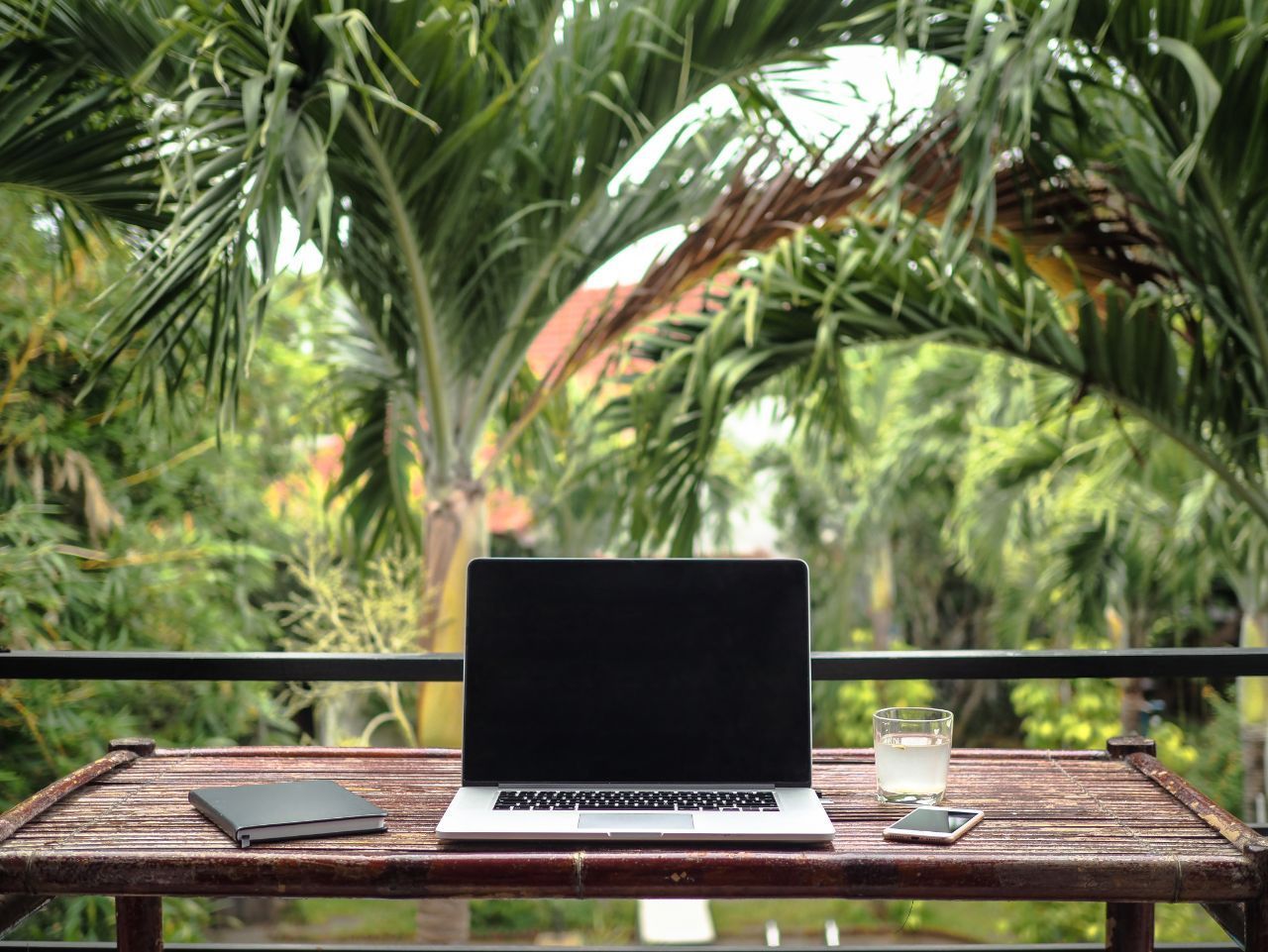 A Laptop Computer is Sitting on a Wooden Table on a Balcony — Gold Coast Detox and Rehab Services in Gold Coast, QLD
