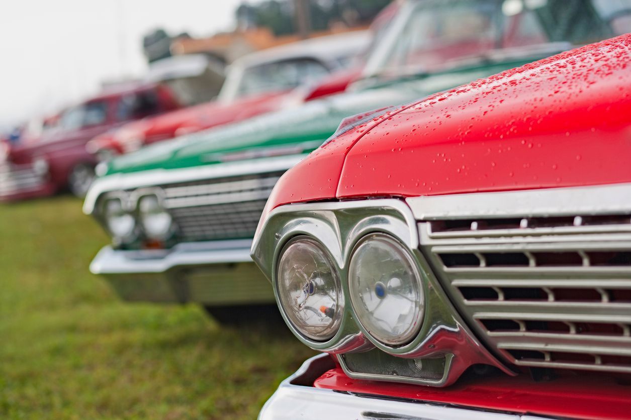 A Row of Old Cars Are Parked in a Grassy Field — Gold Coast Detox and Rehab Services in Gold Coast, QLD