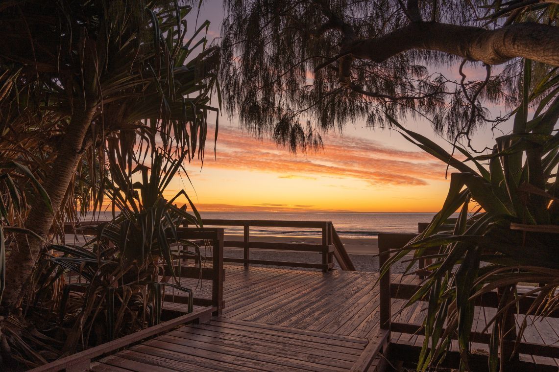 A Wooden Walkway Leading to the Beach at Sunset — Gold Coast Detox and Rehab Services in Gold Coast, QLD