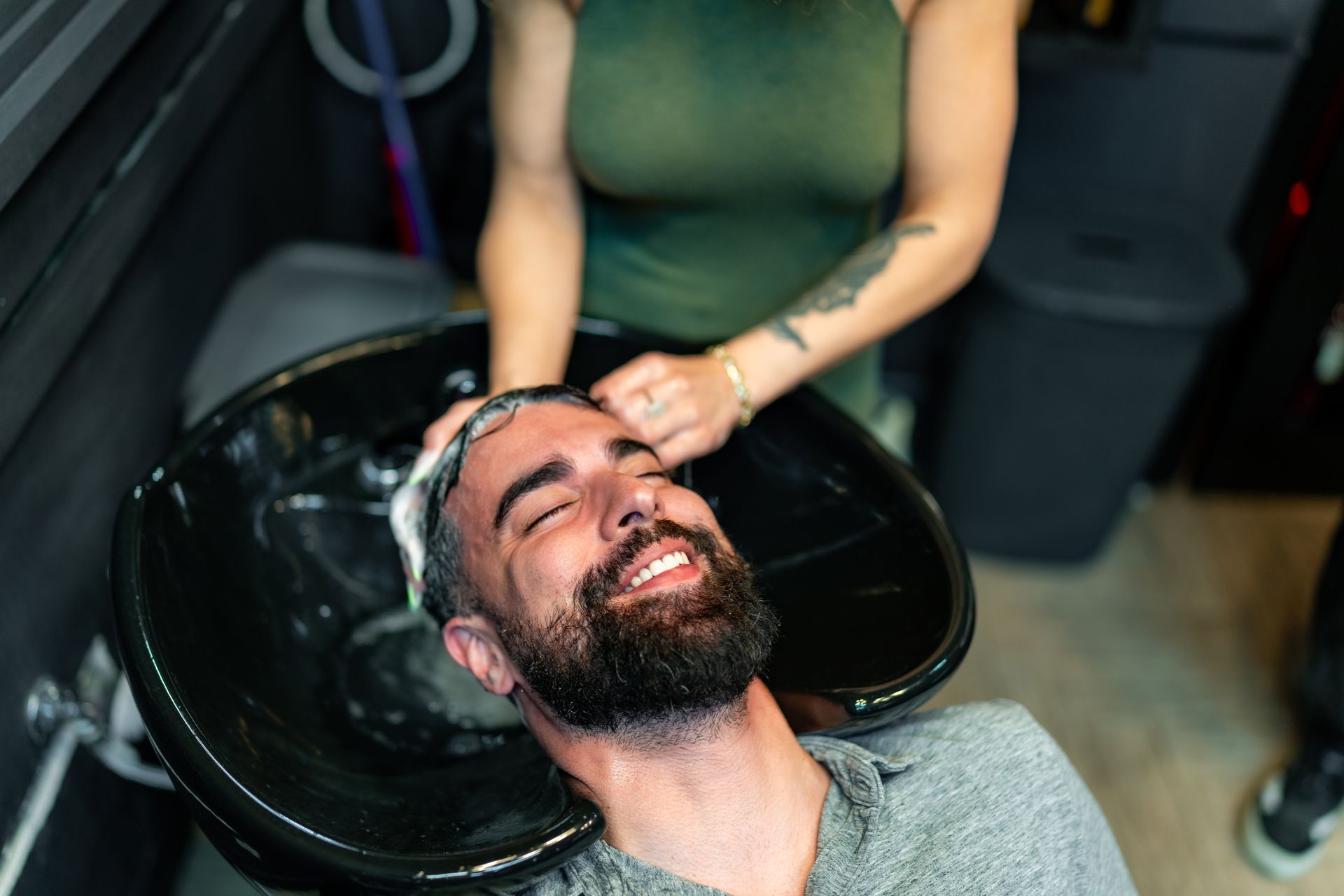 A Man With a Beard is Getting His Hair Washed at a Barber Shop — Gold Coast Detox and Rehab Services in Gold Coast, QLD