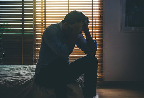 A Sad Man Siting On The Bed — Gold Coast Detox and Rehab Services in Gold Coast, QLD