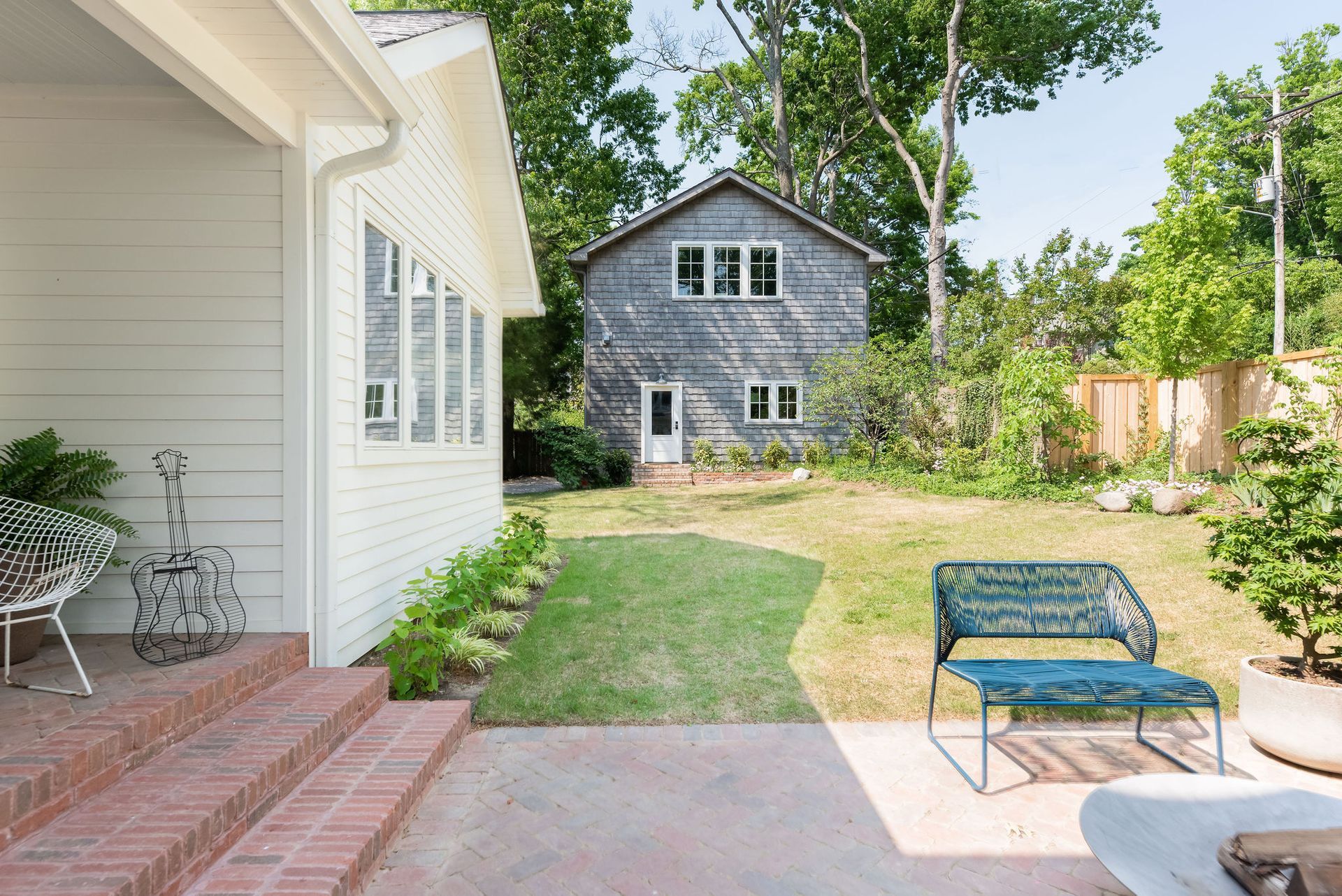 Living room with geometric wall art, green sofa, and eclectic furniture.