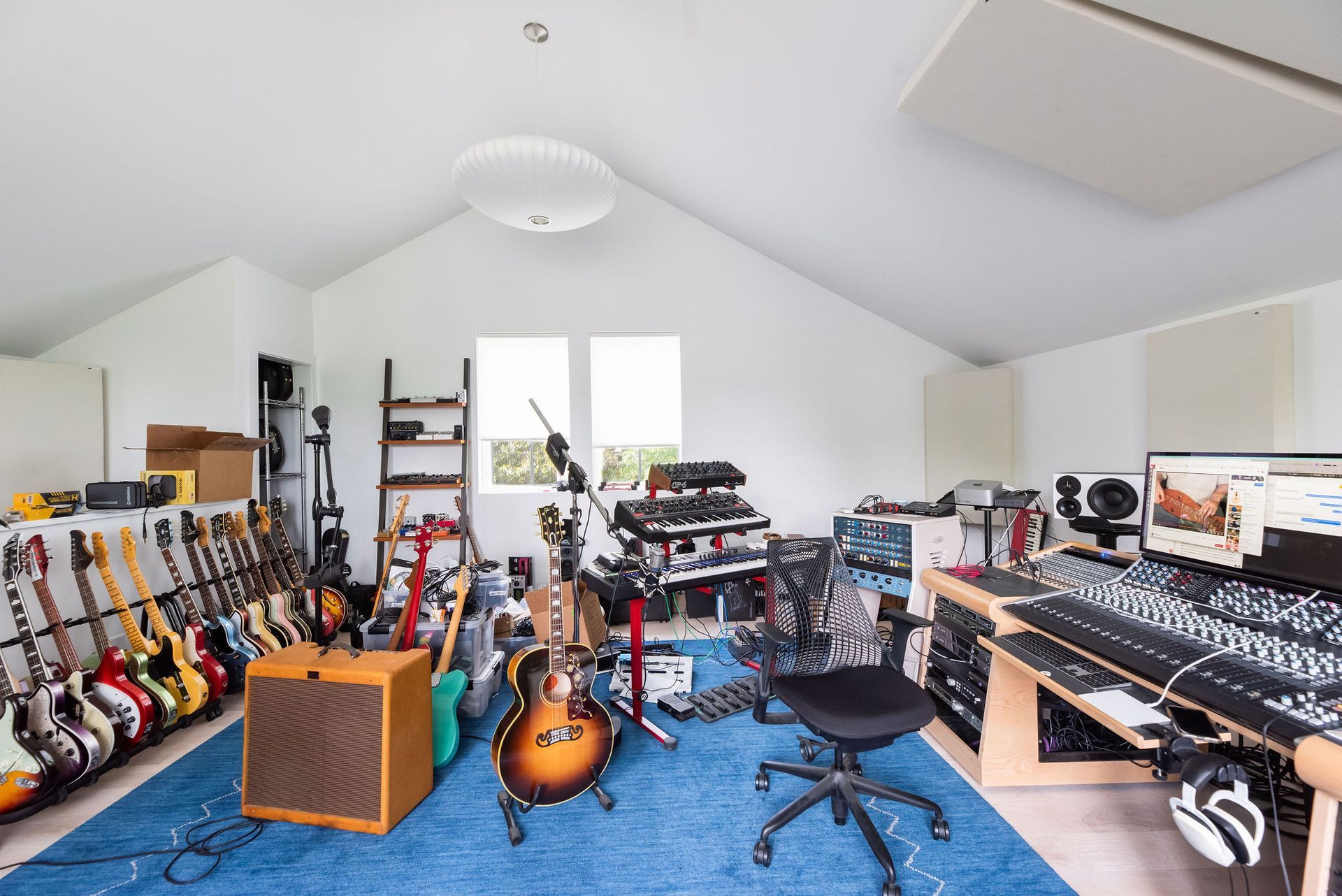 Olive-green shed with black double doors, brown trim, and a white-trimmed gable.