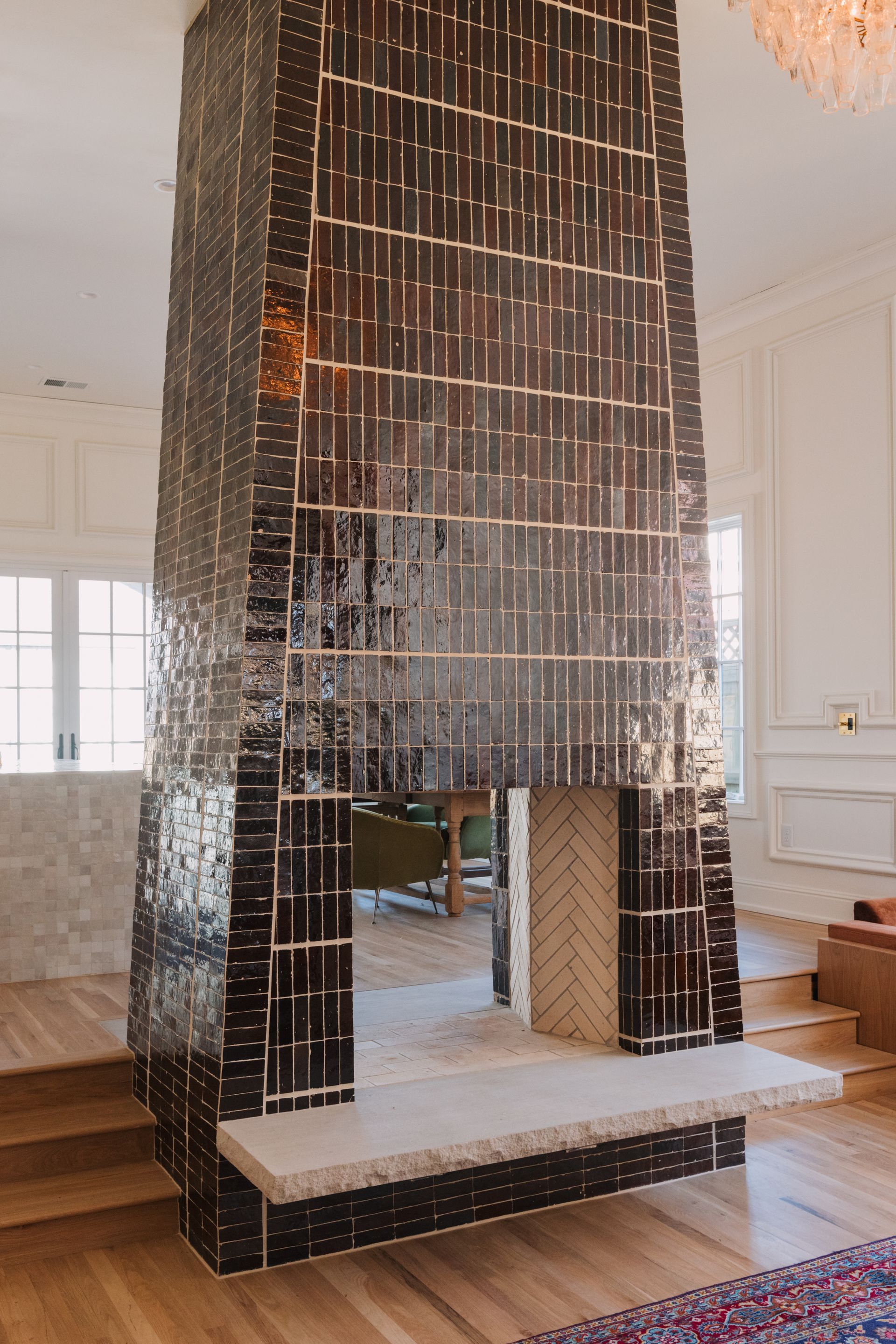 Mirrored black tiled fireplace with a rectangular opening in a bright white room