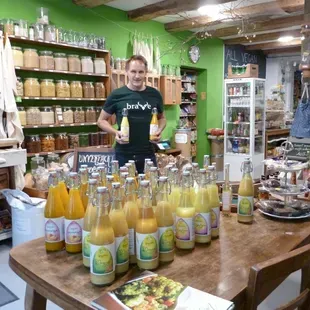 Un homme se tient debout dans un magasin et tient une bouteille de jus d'orange.