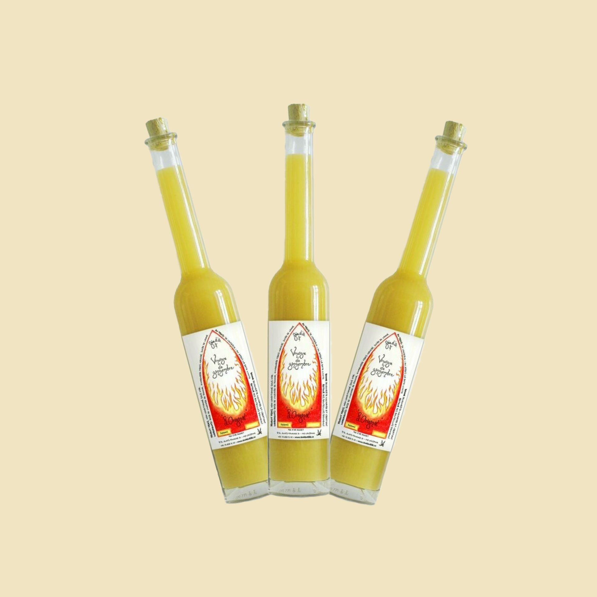 Trois bouteilles de liquide jaune sont posées côte à côte sur une table.