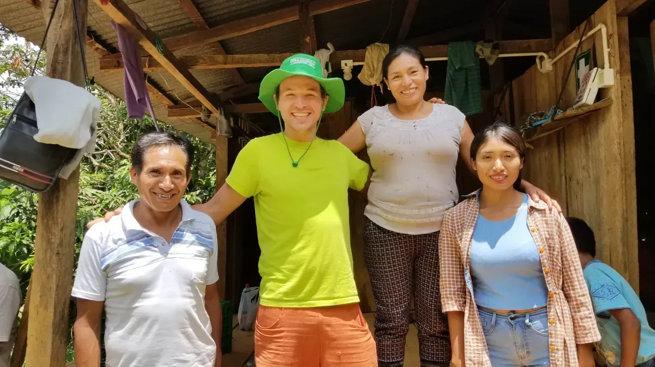 Un groupe de personnes pose pour une photo devant une maison.