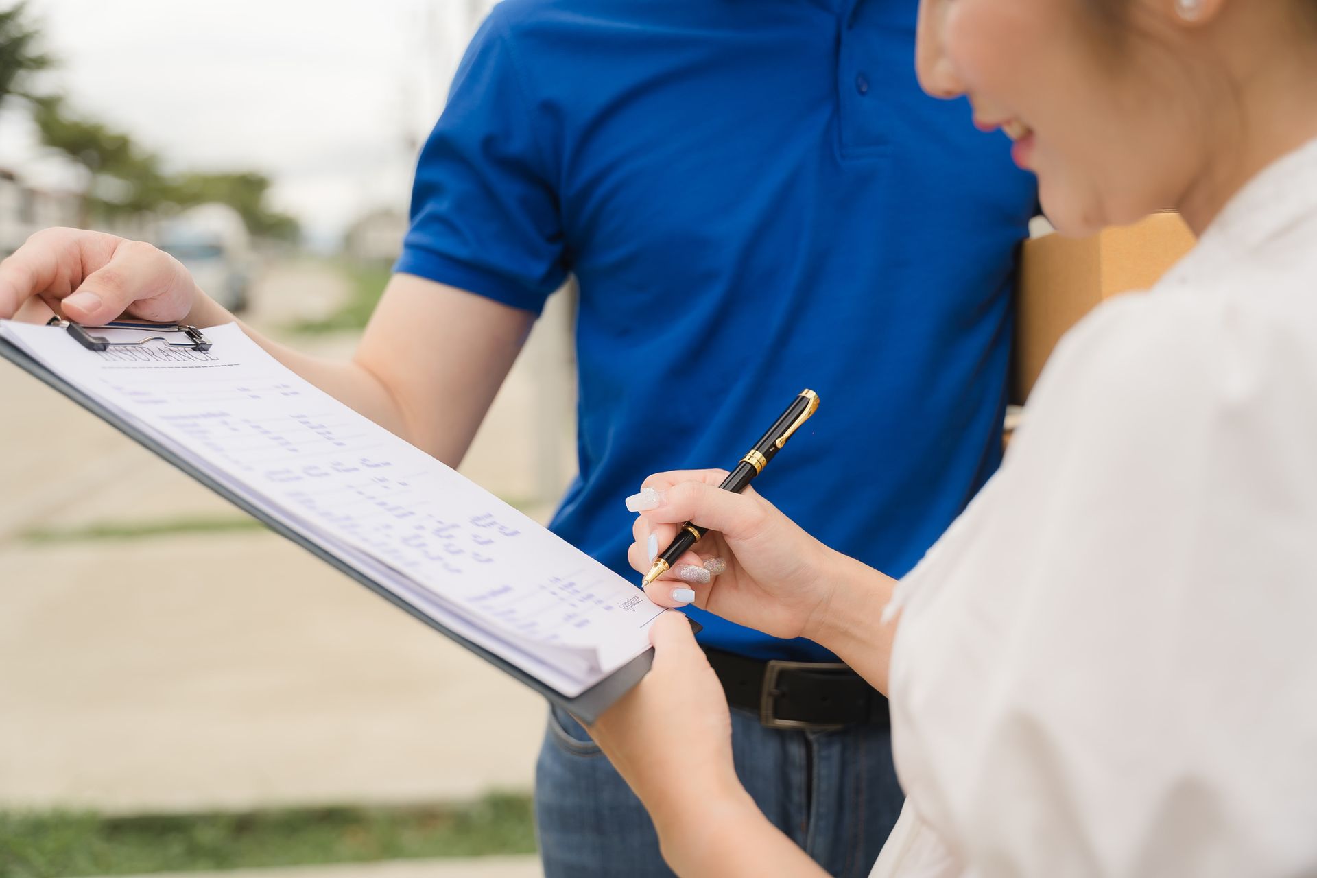 A man and a woman are looking at a clipboard.