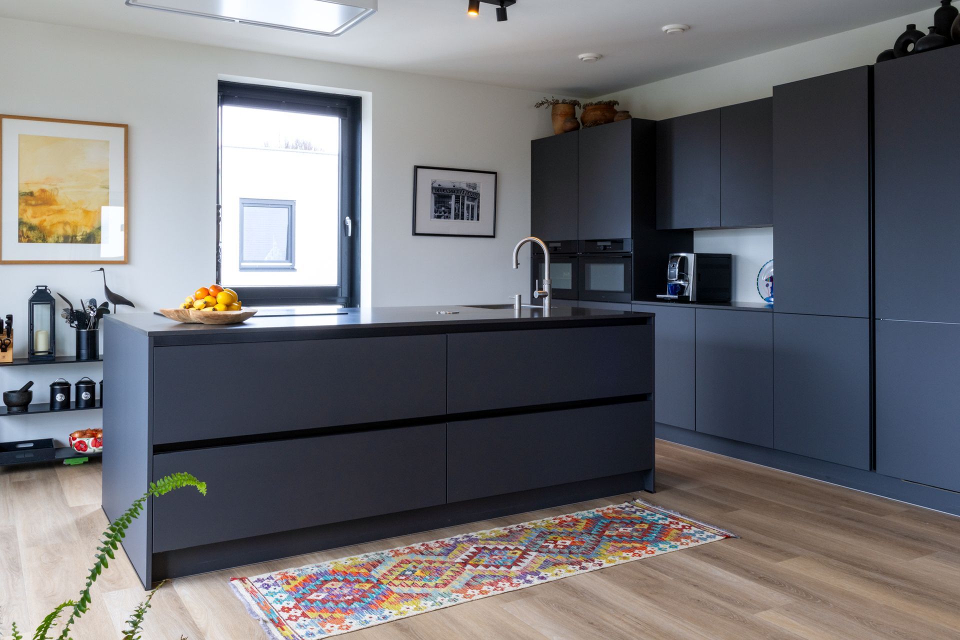 Ruime kamer met een lange houten eettafel, zwarte stoelen, een grote kast en prachtige kamerplanten in een modern penthouse.