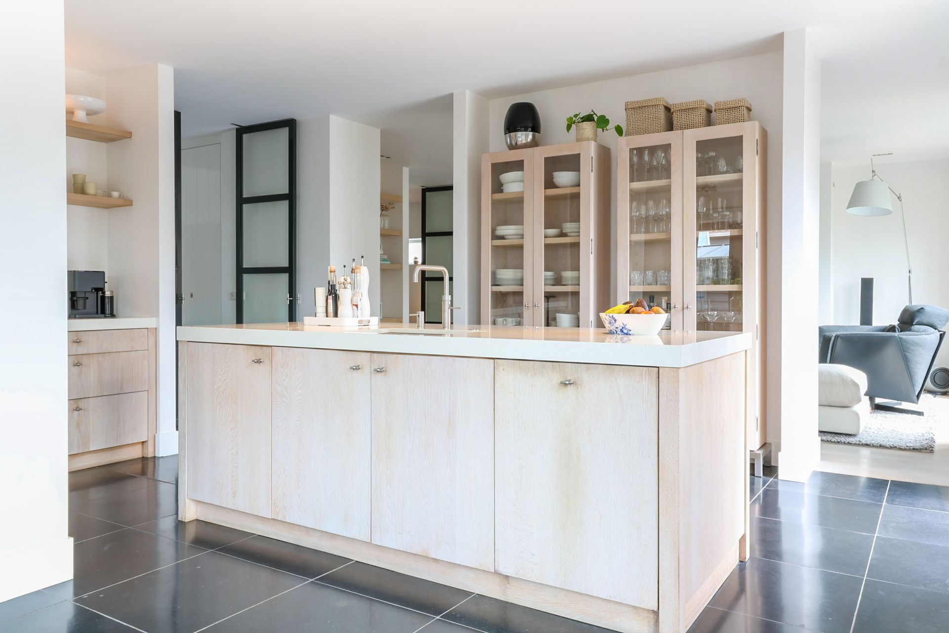 Ruime kamer met een lange houten eettafel, zwarte stoelen, een grote kast en prachtige kamerplanten in een modern penthouse.