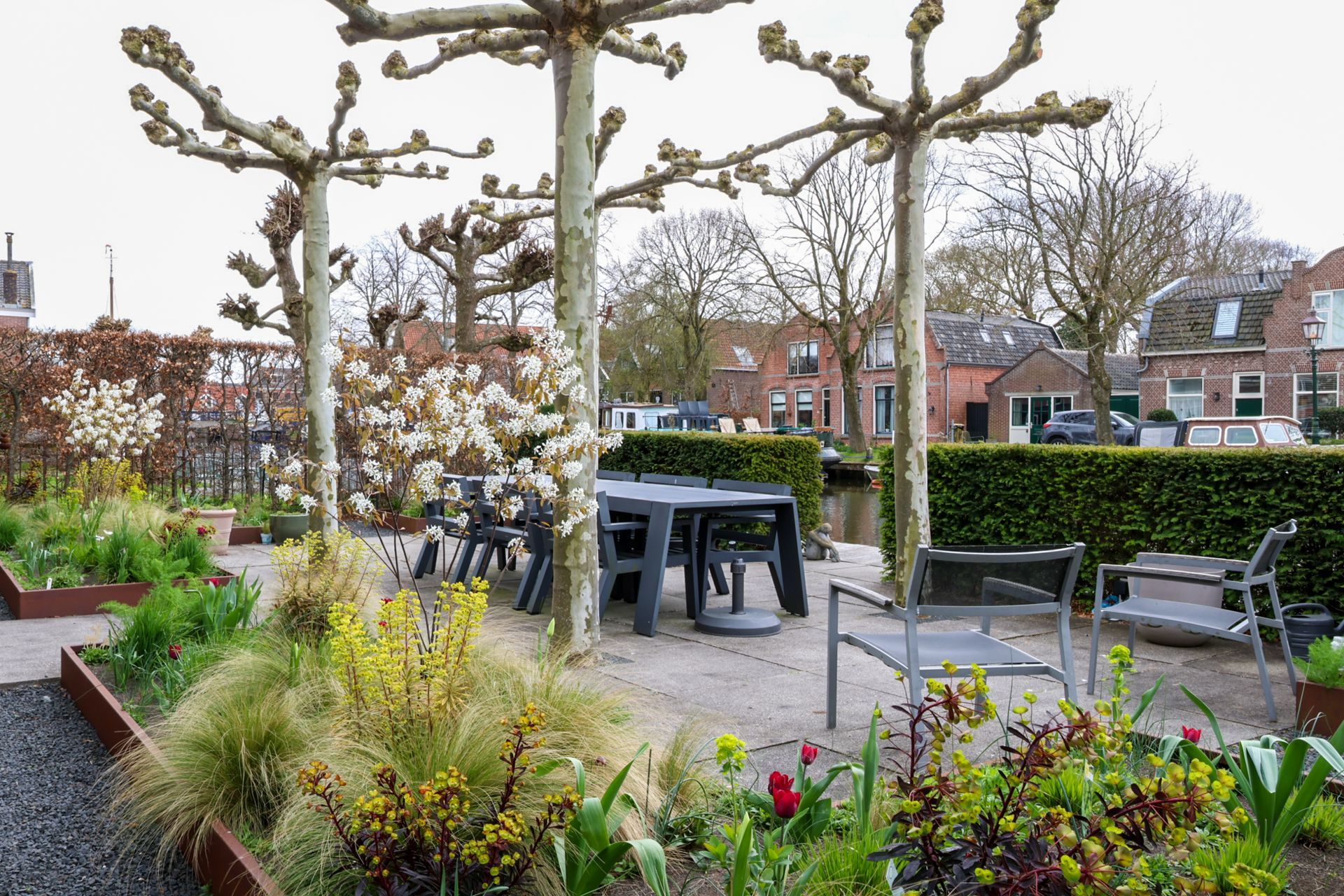 Ruime kamer met een lange houten eettafel, zwarte stoelen, een grote kast en prachtige kamerplanten in een modern penthouse.