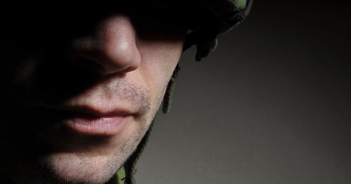 a close up of a man 's face with a helmet on