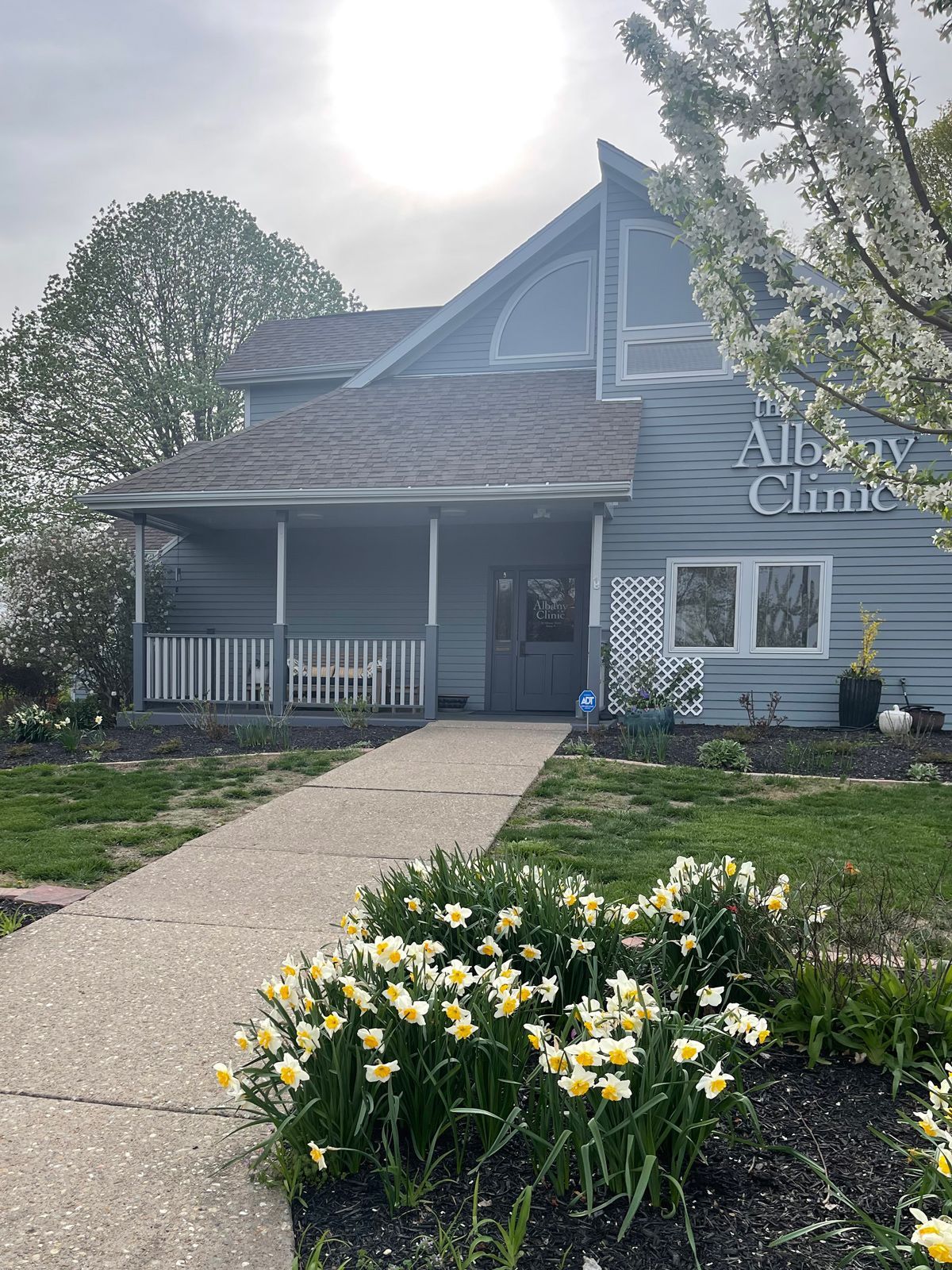 the albany clinic in carbondale Illinois has a porch and flowers in front of it.