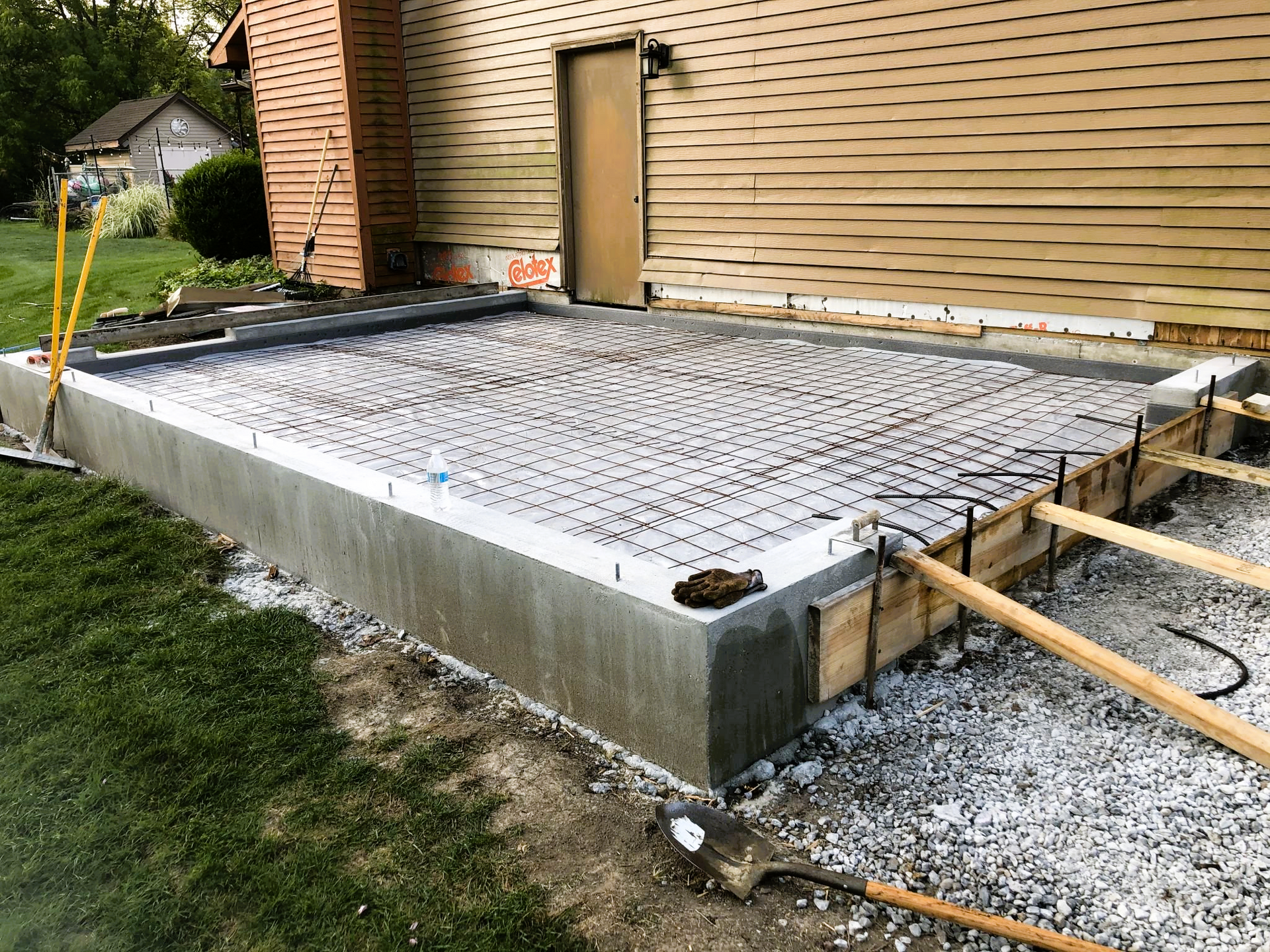 A concrete slab is being built in front of a house.