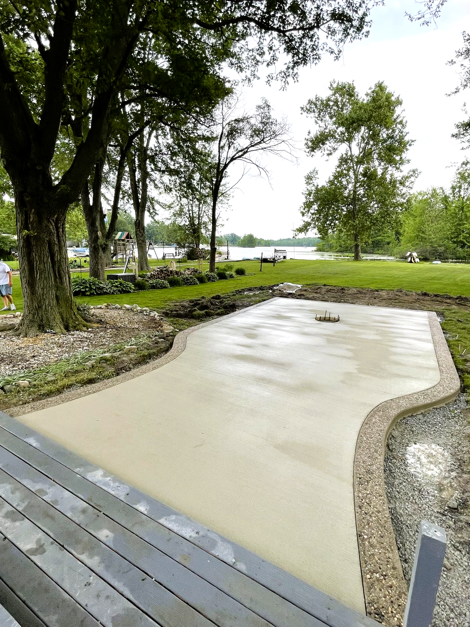 A concrete driveway is being built in a park with trees in the background.