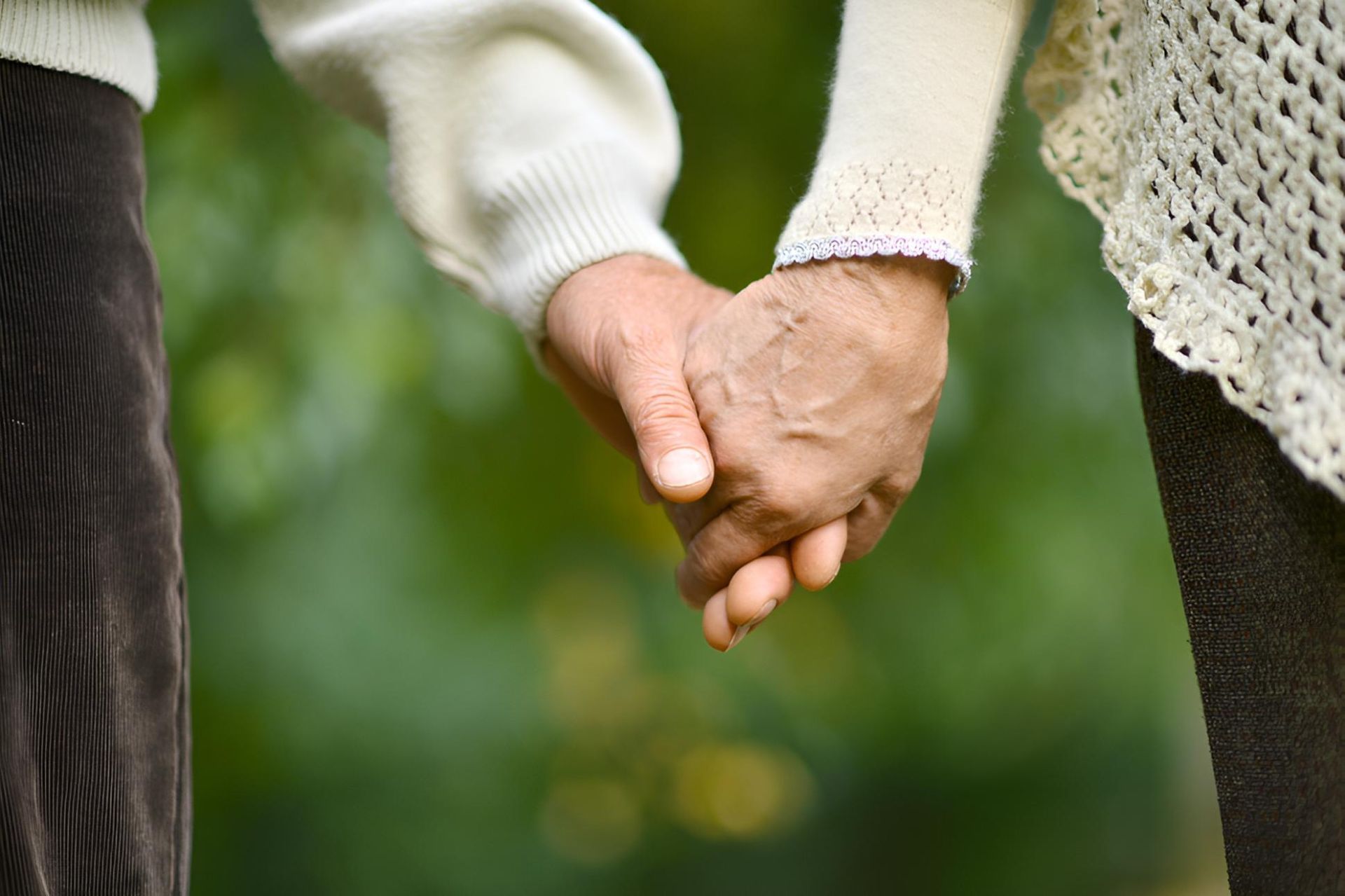 A Man and a Woman Are Holding Hands in a Park — Active Lifestyle Supports In Tullimbar, NSW