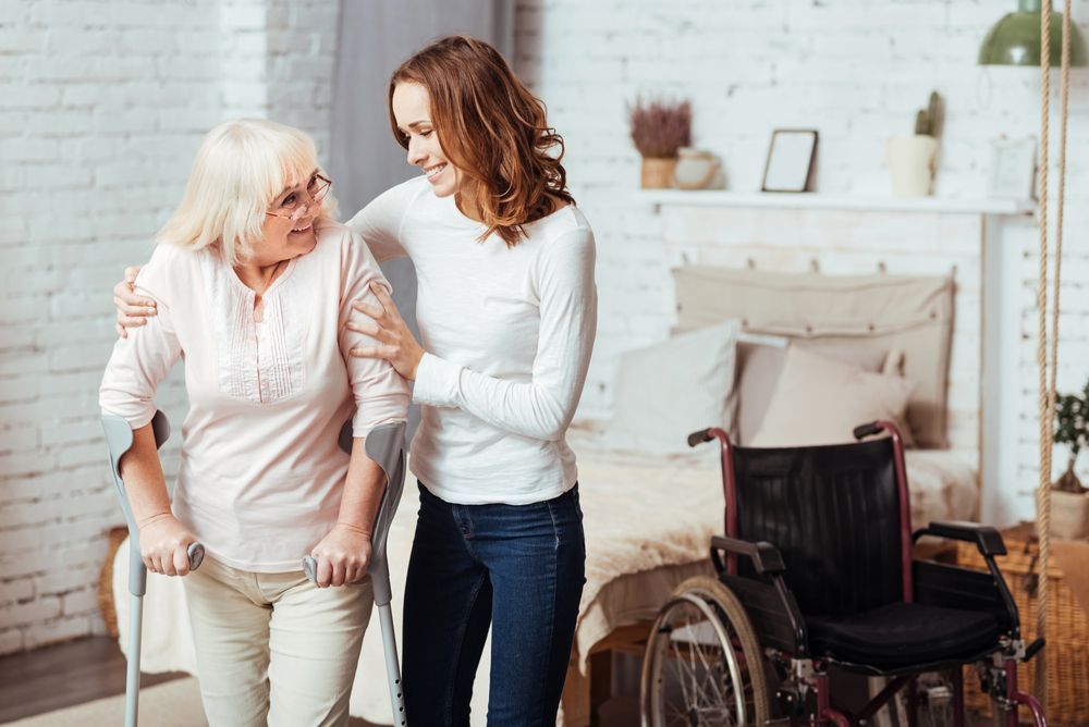 Care Worker Helping Disabled Elderly Woman on Crutches — Active Lifestyle Supports In Tullimbar, NSW