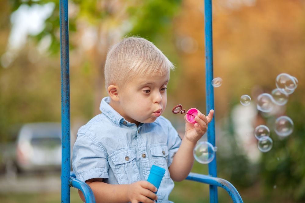Young Boy With Downs Syndrome Blowing Bubbles — Active Lifestyle Supports In Tullimbar, NSW