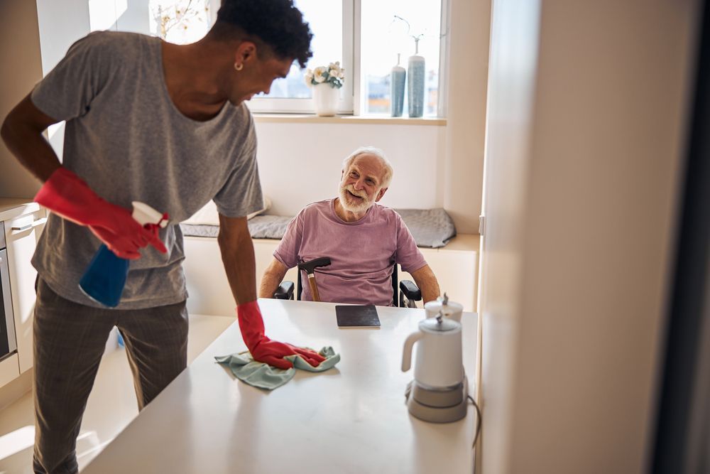 Volunteer Helping Man Cleaning Desk With an Elderly Man at Home — Active Lifestyle Supports In Tullimbar, NSW