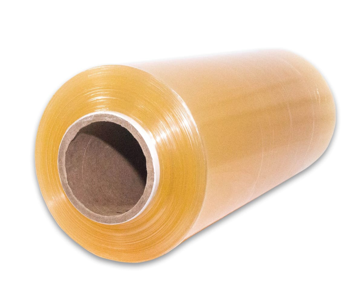 Rollo de film plástico transparente sobre un núcleo de cartón, dispuesto en ángulo sobre una superficie blanca.