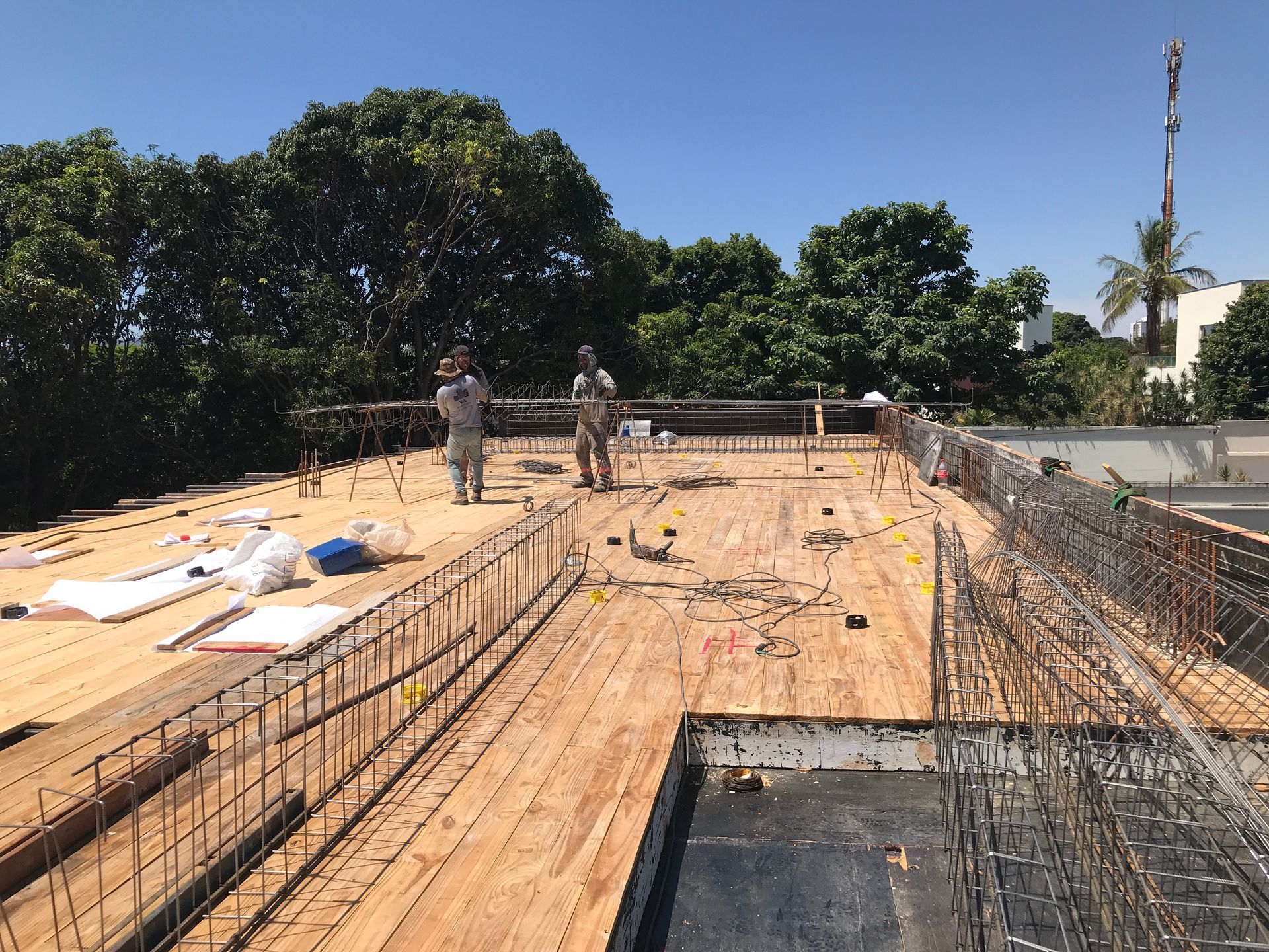 Um grupo de trabalhadores da construção civil está em pé no topo de um deck de madeira.