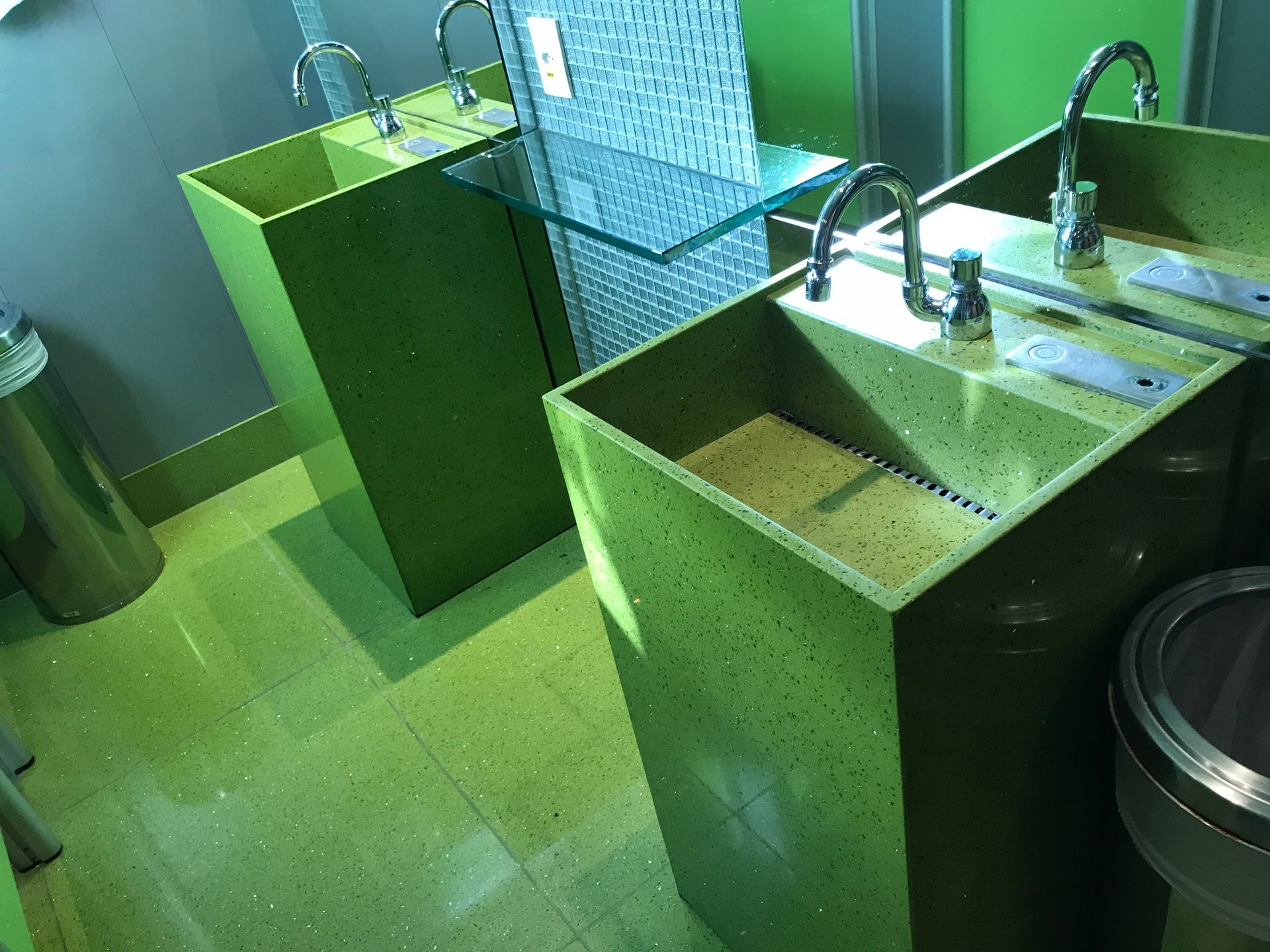 Um banheiro com duas pias verdes e um vaso sanitário