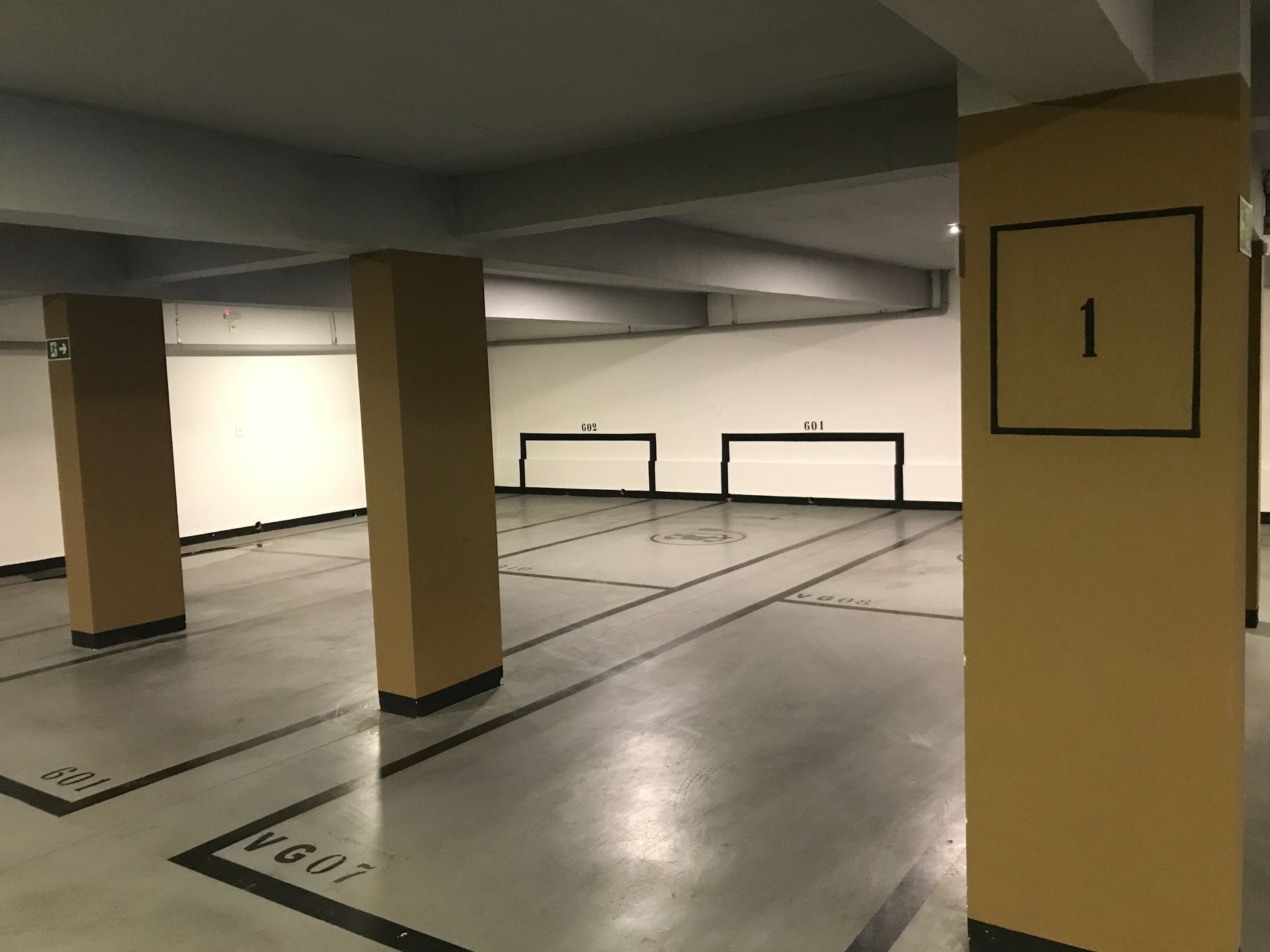 Uma garagem vazia com colunas e uma placa que diz 1